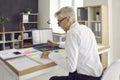 Senior man working at office desk with papers, post-it notes and laptop computer Royalty Free Stock Photo