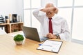 Senior man working at the office using computer laptop covering eyes with arm smiling cheerful and funny Royalty Free Stock Photo