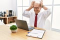 Senior man working at the office using computer laptop doing bunny ears gesture with hands palms looking cynical and skeptical Royalty Free Stock Photo