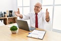 Senior man working at the office using computer laptop looking at the camera smiling with open arms for hug Royalty Free Stock Photo