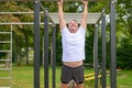 Senior man working out on parallel bars in a park in spring Royalty Free Stock Photo