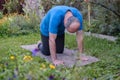 Senior man working out in yoga, pilates bend in Cat yoga Pose, Marjaryasana Royalty Free Stock Photo