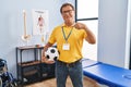 Senior man working at sport physiotherapy clinic pointing finger to one self smiling happy and proud Royalty Free Stock Photo