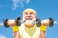 Senior man workout in rehabilitation center. Elderly man practicing sports on blue sky background. Senior fitness man Royalty Free Stock Photo