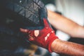 Senior man in workshop. Man takes car tire. Royalty Free Stock Photo