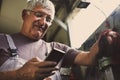 Senior man in workshop using smart phone. Royalty Free Stock Photo