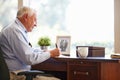 Senior Man Writing Memoirs In Book Sitting At Desk Royalty Free Stock Photo