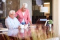 Senior Man Writing Memoirs In Book Sitting At Desk