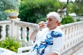 Senior man of 60 years drinking glass of rose wine on vacations. Retired man enjoying warm summer evening