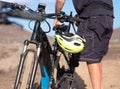 Senior man 70 years old doing sport with his bici. Electric bicycle. Yellow helmet. Outdoor activity in arid footpath under sunset Royalty Free Stock Photo