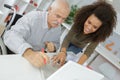 senior man and young woman smiling and looking at laptop Royalty Free Stock Photo