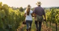 Senior man with young woman walking on the vineyard, rear view Royalty Free Stock Photo