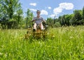 Senior man on zero turn lawnmower in meadow Royalty Free Stock Photo