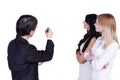 A senior manager in a suit draws a marker diagram for two girls from his department