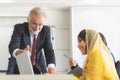 Senior manager training young intern trainee to use application in computer Royalty Free Stock Photo