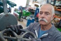 Senior manual worker turning cut-off valve at plant Royalty Free Stock Photo