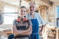 Senior master carpenter with his granddaughter in the wood workshop