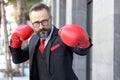 Senior mature bearded businessman wearing red boxing gloves or mitt punch, the metaphors about fight business for successful,