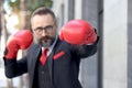 Senior mature bearded businessman wearing red boxing gloves or mitt punch, the metaphors about fight business for successful,