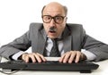 Mature business man with bald head on his 60s working stressed and surprised at office computer laptop desk looking in shock Royalty Free Stock Photo