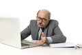 Senior mature busy business man with bald head on his 60s working stressed and frustrated at office computer laptop desk looking a Royalty Free Stock Photo