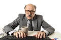 Senior mature busy business man with bald head on his 60s working stressed and frustrated at office computer laptop desk looking a Royalty Free Stock Photo