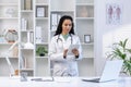 Senior mature female doctor serious and confident thoughtfully using tablet computer, Latin American woman in medical Royalty Free Stock Photo