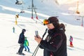 Senior mature skier making selfie with modern camera phone at winter alpine skiing resort. Old aged sporty person using smartphone
