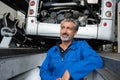 Senior mechanic stood in pit under bus Royalty Free Stock Photo
