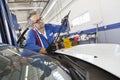 Senior mechanic working on windshield wipers Royalty Free Stock Photo