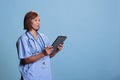 Senior medical assistant looking at tablet computer checking disease expertise