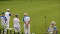 Senior members oap pensioners playing bowls bowling green outdoors active sports