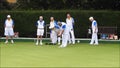 Senior members oap pensioners playing bowls bowling green outdoors active sports