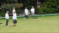 Senior members oap pensioners playing bowls bowling green outdoors active sports