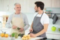 Senior man with beard preparing dinner with son Royalty Free Stock Photo