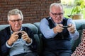 Senior Men Engrossed in Video Gaming on Couch Royalty Free Stock Photo