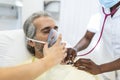 Senior man getting an oxygen mask from doctor to help him better breath during coronavirus covid-19 healthcare crisis. Medical Royalty Free Stock Photo