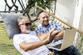 Senior men lying on a hammock using a laptop Royalty Free Stock Photo