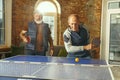 Senior men playing table tennis in workplace, having fun Royalty Free Stock Photo