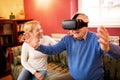 Senior man using virtual reality simulator and having fun with n