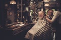 Senior man visiting hairstylist in barber shop.