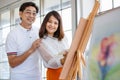 Senior man and woman couple, husband and wife, painting image together in home gallery with warm and happy circumstance. The man