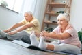 Senior couple doing yoga together at home health care legs stretching Royalty Free Stock Photo