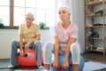 Senior couple exercise together at home doing aerobics with dubbells down