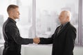 Senior and mid-adult businessman shaking hands Royalty Free Stock Photo