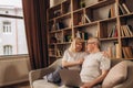 Senior middle aged happy couple embracing using laptop together, smiling elderly family reading news, shopping online at Royalty Free Stock Photo