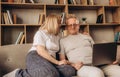 Senior middle aged happy couple embracing using laptop together, smiling elderly family reading news, shopping online at Royalty Free Stock Photo