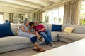 Senior mixed race couple sitting on the couch with their young  granddaughter Royalty Free Stock Photo