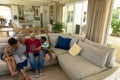 Senior mixed race couple sitting on the couch with their young grandson and granddaughter Royalty Free Stock Photo