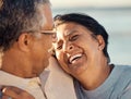 A senior mixed race couple walking together on the beach smiling and laughing on a day out at the beach. Hispanic Royalty Free Stock Photo